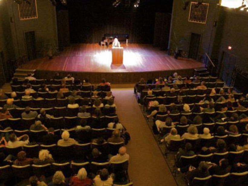 writer on stage reading to audience