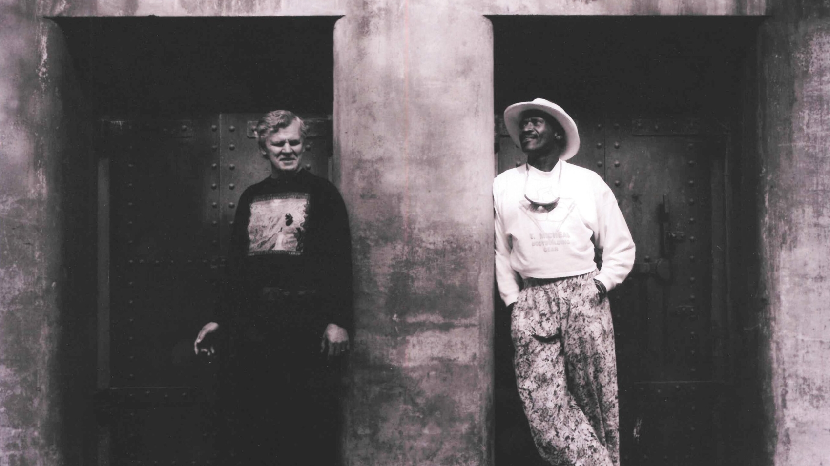 Doc Watson and Taj Mahal in front of a bunker in Fort Worden State Park in 1990, photo by Paul Boyer.