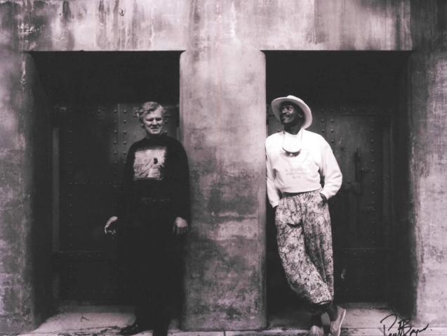 Doc Watson and Taj Mahal in front of a bunker in Fort Worden State Park in 1990, photo by Paul Boyer.