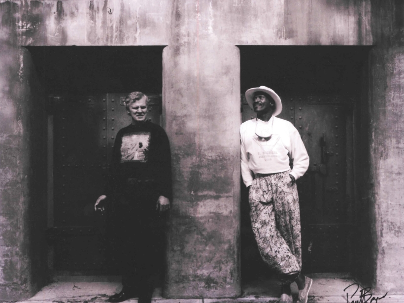 Doc Watson and Taj Mahal in front of a bunker in Fort Worden State Park in 1990, photo by Paul Boyer.